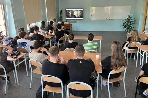 Uczniowie siedzą w sali na wykładzie