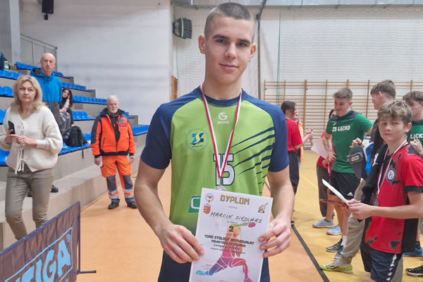 Uczeń stoi z dyplomem