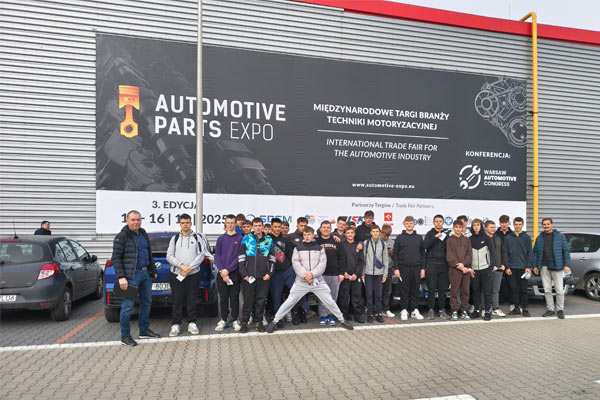 Uczniowie przed zakładem motoryzacyjnym