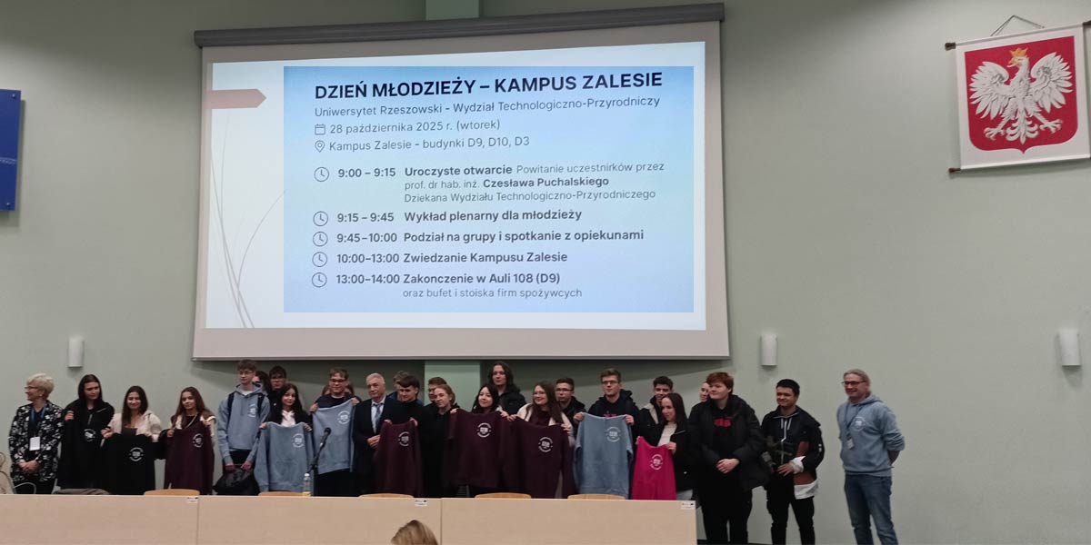 Uczniowie stoją pod tablicą projekcyjną