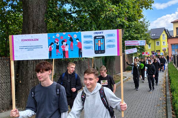 Uczniowie idą z transparentami o uzależnieniach
